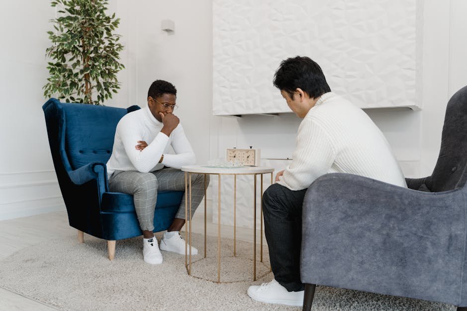 Two men deeply focused on a chess game in a modern indoor setting.